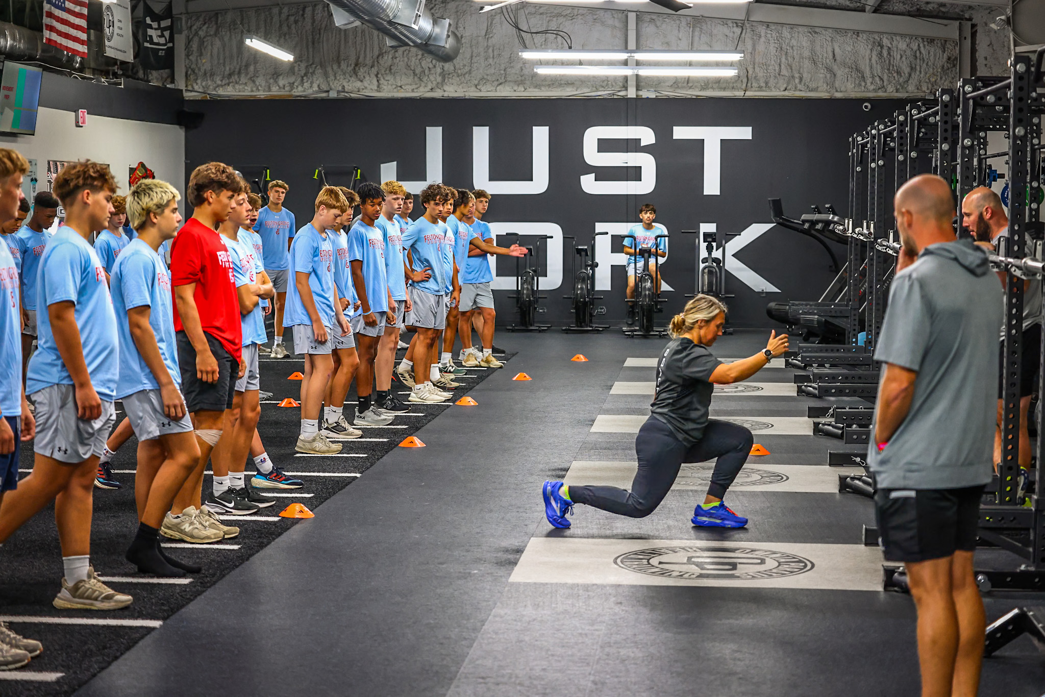 Coach leading a group of athletes in a training gym — learn from someone who's done it